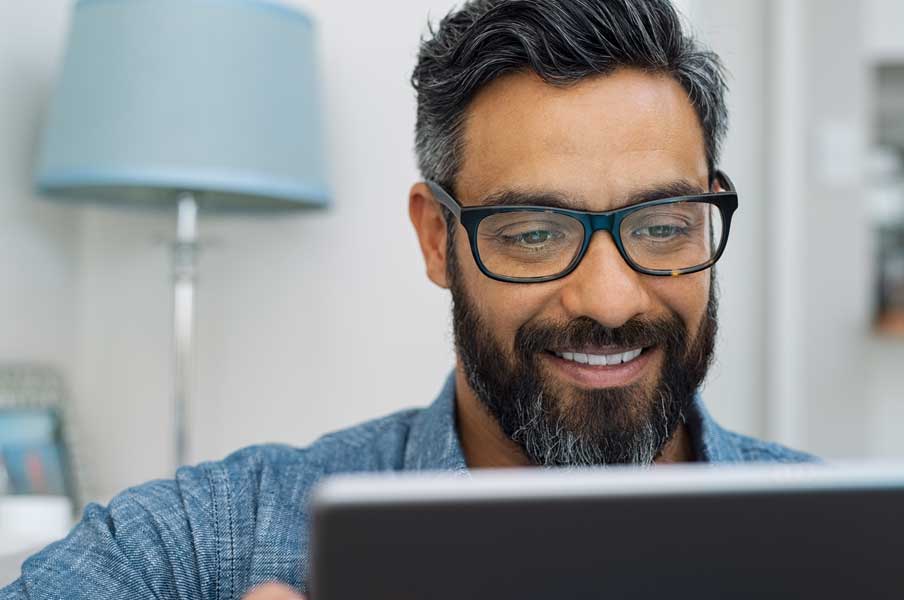 Man looking at laptop on a video consult.